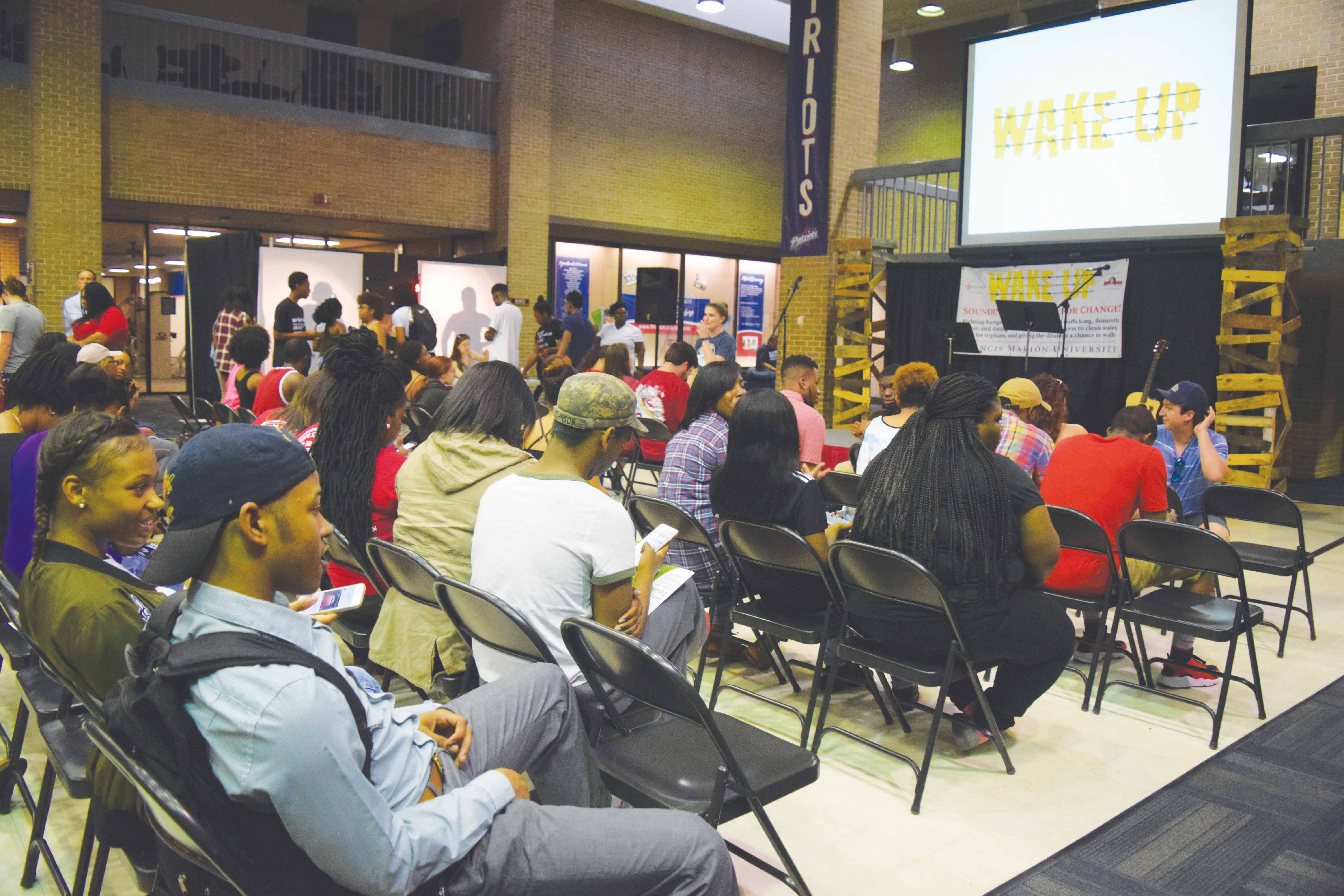 Students gather in the UC Commons during the WakeUp event to learn about social issues that affect people globally such as world hunger, clean water and sex trafficking.
