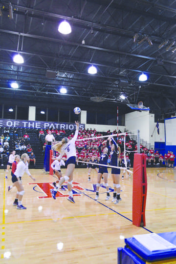 Junior Carlie Smith (8), an outside hitter, jumps towards the ball for a spike as the Jaguars get ready to defend their side.