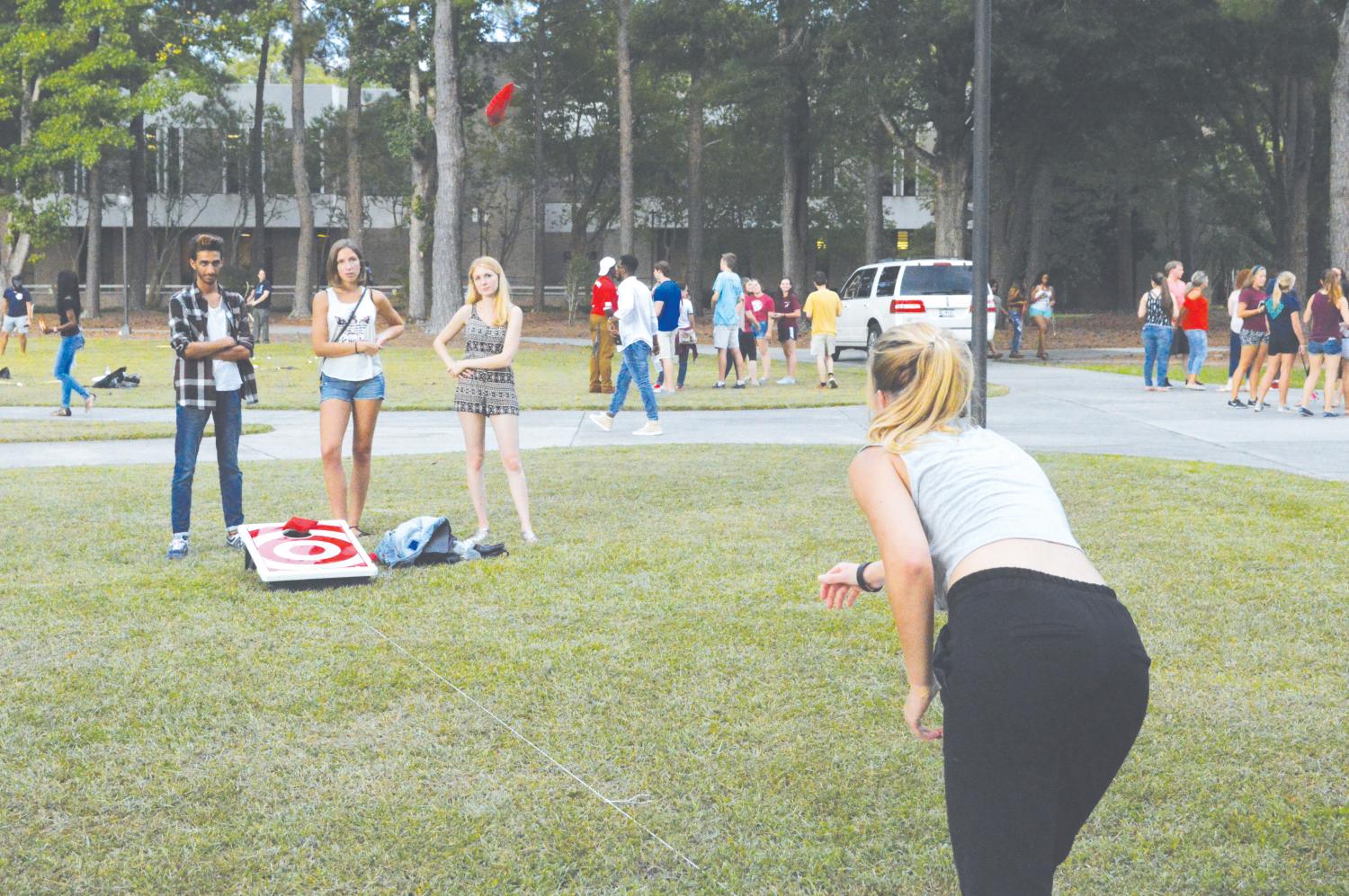 International students enjoy playing cornhole and socializing during cookout hosted by BCM. Students play other games such as archery tag.