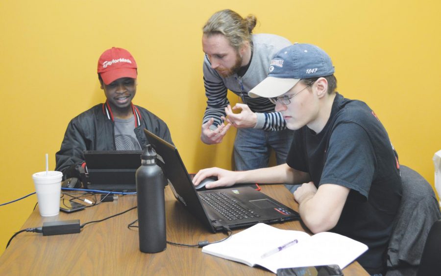 FMU students James McCarley and Laurence Martin work with programmer Bryant Ward on the “Whose Lips” game at the Kelley Center for Enterprise and Innovation. 