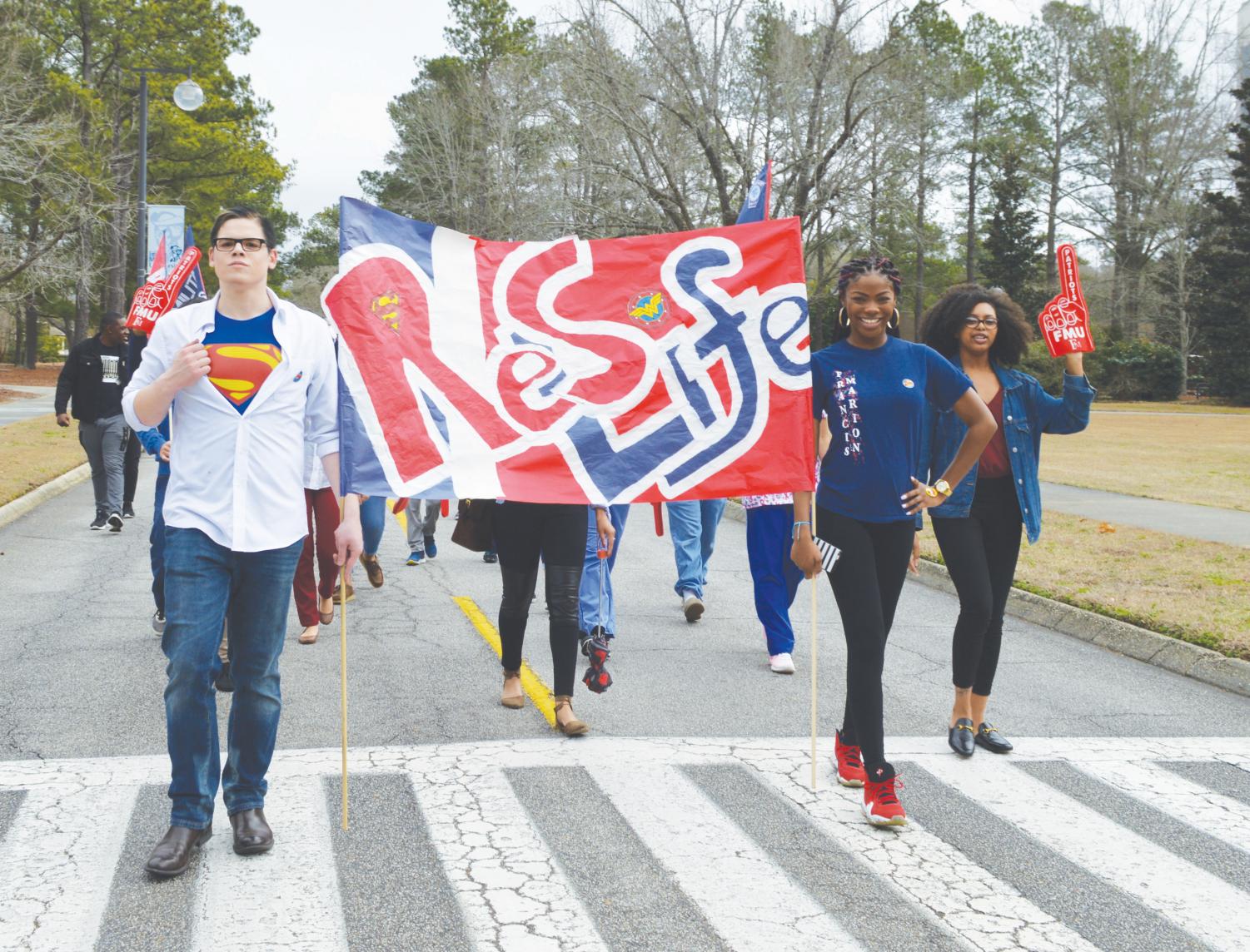 Clubs and organizations design golf carts and banners, which match the parade theme: Homecoming Heroes.