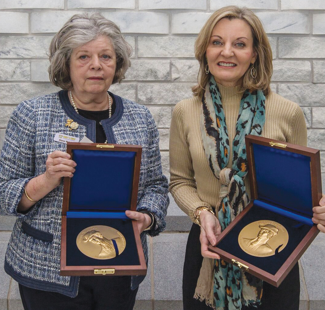 Dianne Welsh and Pennie Burns, on behalf of their father Wilbur Owens, receive the 2018 Marion Medallions.