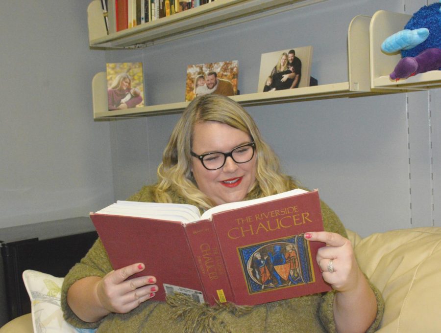Assistant professor of English Megan Woosley-Goodman, who enjoys old English, sits and read her favorite book. 
