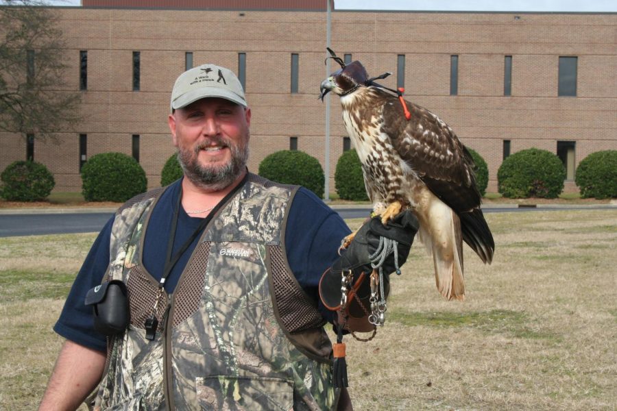 Joel King poses with his juvenile red-tailed hawk, Stella.