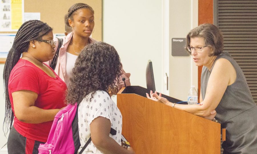 Deborah Potter speaks with FMU students after her presentation. 