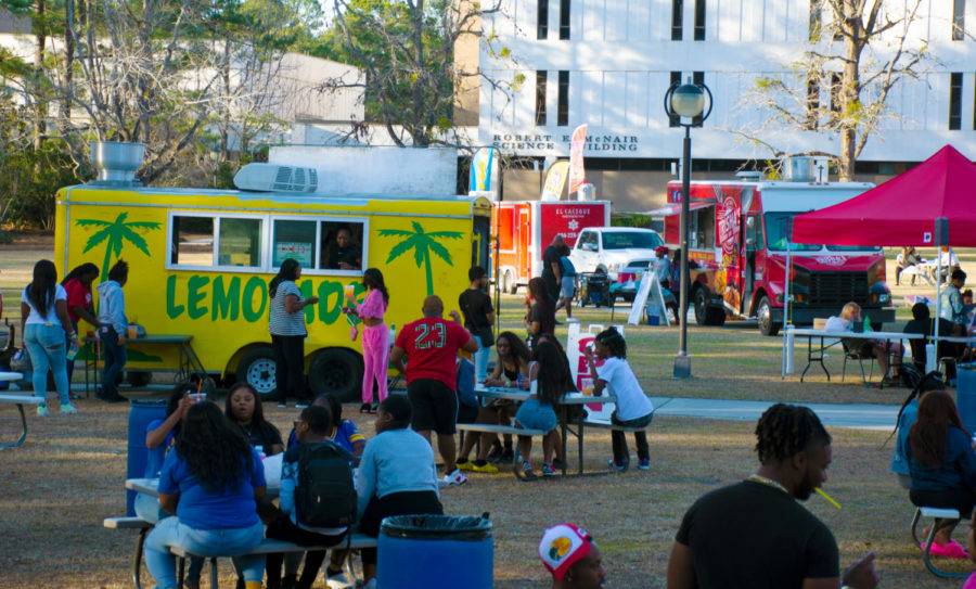 Students gather around the food trucks and populate picnic tables at FMU's
