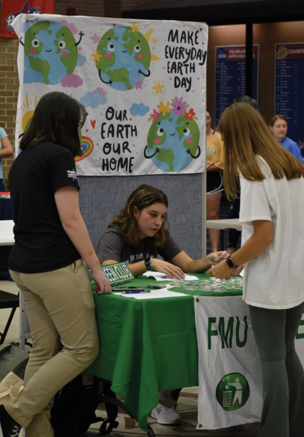 FMU Green Club talks to a potential new member at their table in the Student Activities Fair.