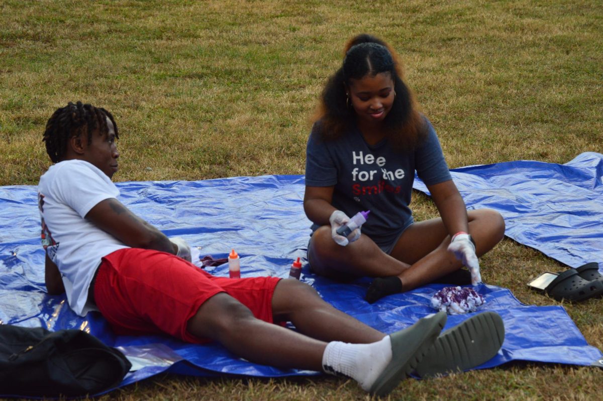 Students are seen using T-shirt dye atop blue tarps for the "CAB After Class: Tie-Dye Bash" (Sept. 22, 2025).